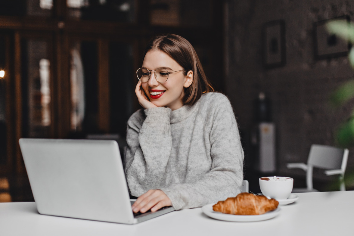 Girl smiing at a Laptop